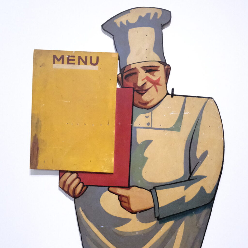 ancienne enseigne MENU avec cuisinier peint portant le menu