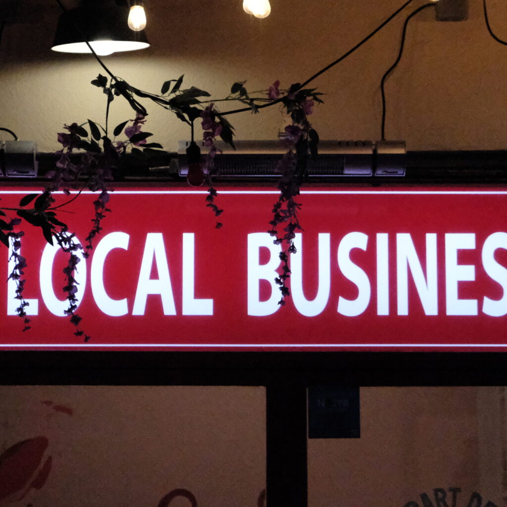 Local business inscription coupée sur enseigne éclairée la nuit